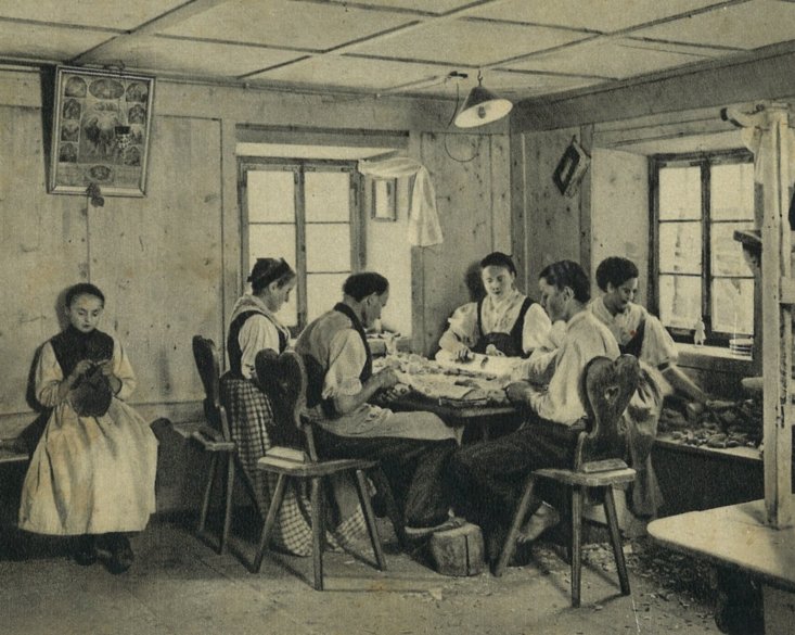 La familia Ploner che zipla pra mëisa te stua de Corpomio y Maria che fej ciauza senteda sun banch (ora dl liber dl Museum - Chiena de Gherdëina, 1994, pl. 19) La familia Ploner che zipla pra mëisa te stua de Corpomio y Maria che fej ciauza senteda sun banch (ora dl liber dl Museum - Chiena de Gherdëina, 1994, pl. 19)